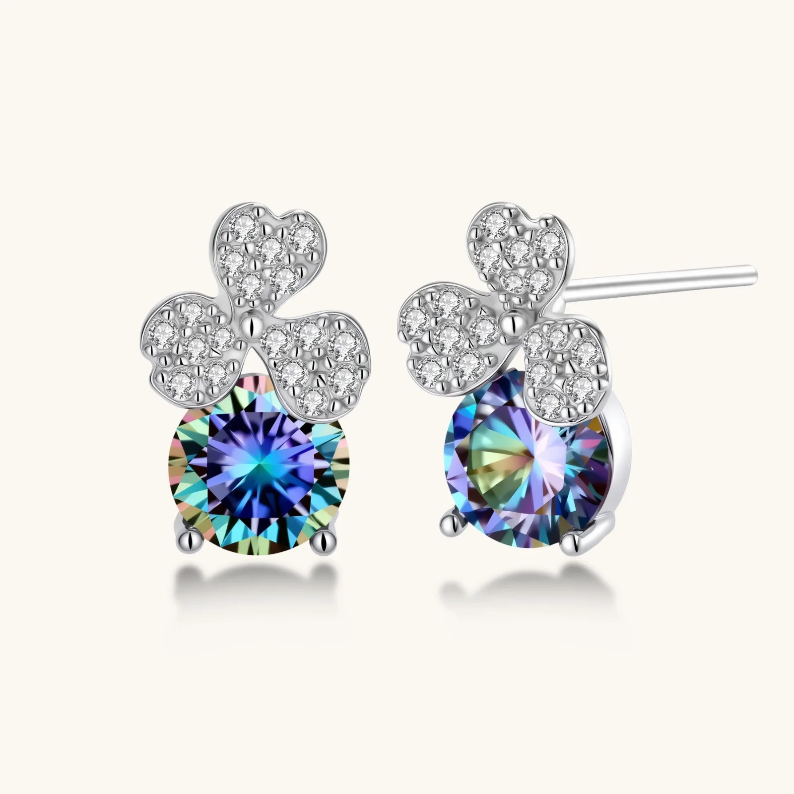 Sterling silver jewelry set with rainbow moissanite stones in clover and butterfly designs on cream background