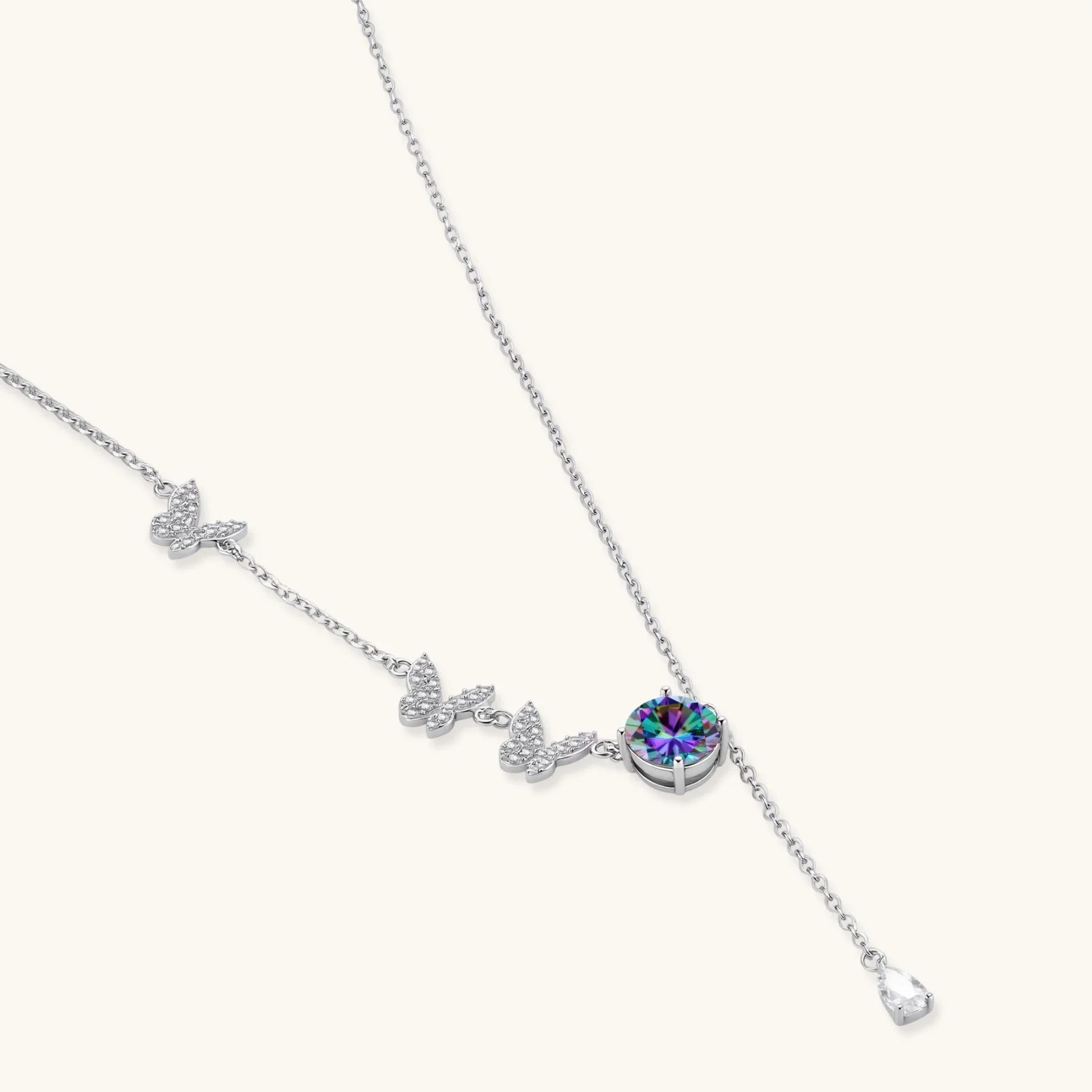 Sterling silver jewelry set with rainbow moissanite stones in clover and butterfly designs on cream background