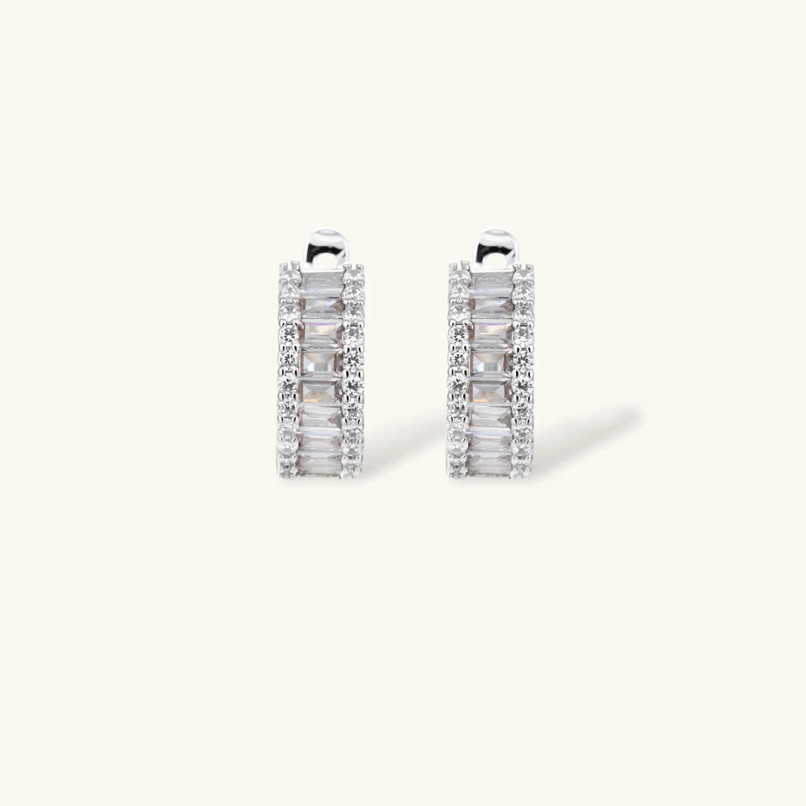 White gold plated necklace with vertical cubic zirconia pendant and matching hoop earrings on neutral background