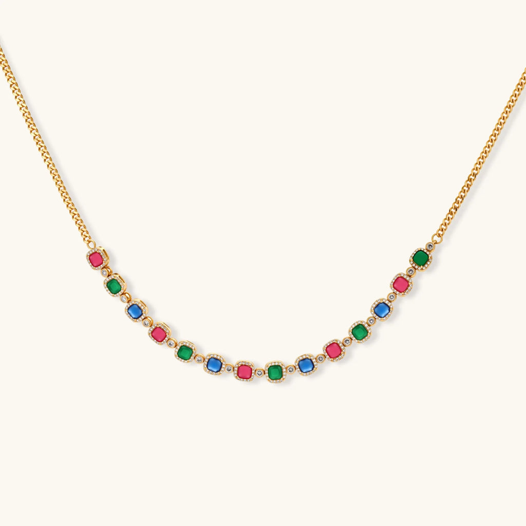 Gold-plated jewelry set with red, green, and blue cubic zirconia stones including necklace, bracelet, and drop earrings.