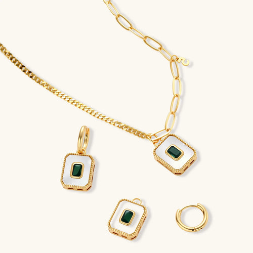 Gold-plated jewelry set with white enamel square pendants and emerald CZ stones on cream background.