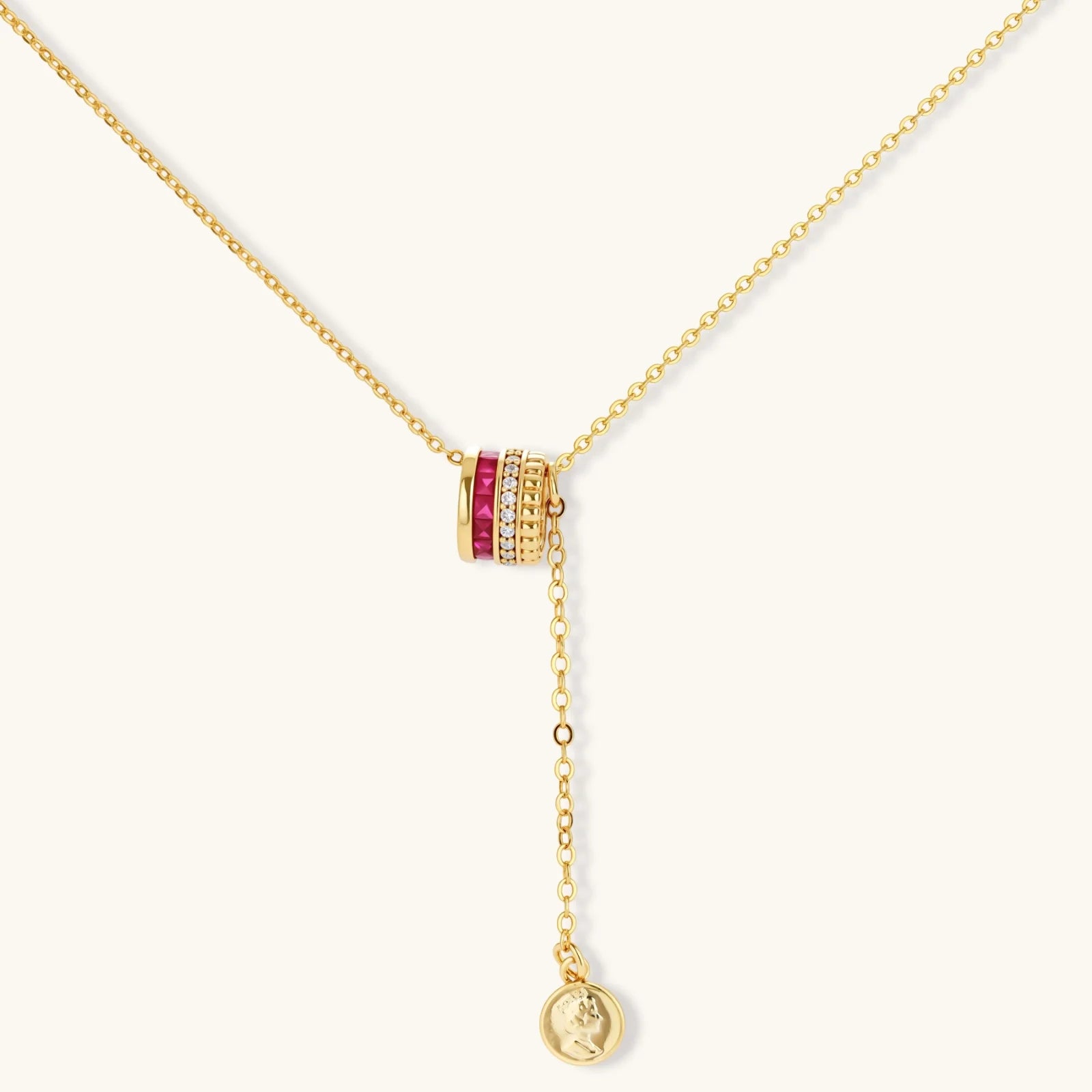 Three-piece jewelry set featuring 14K gold plated pieces with deep red cubic zirconia stones and clear crystals on cream background.