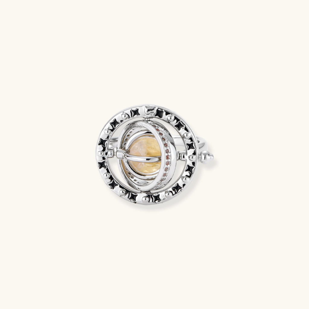 Adjustable brass ring with rotating zirconia center, surrounded by black enamel celestial stars and moon details