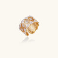 Two-tone gold and silver lattice ring with clover pattern and crystal accents on white background