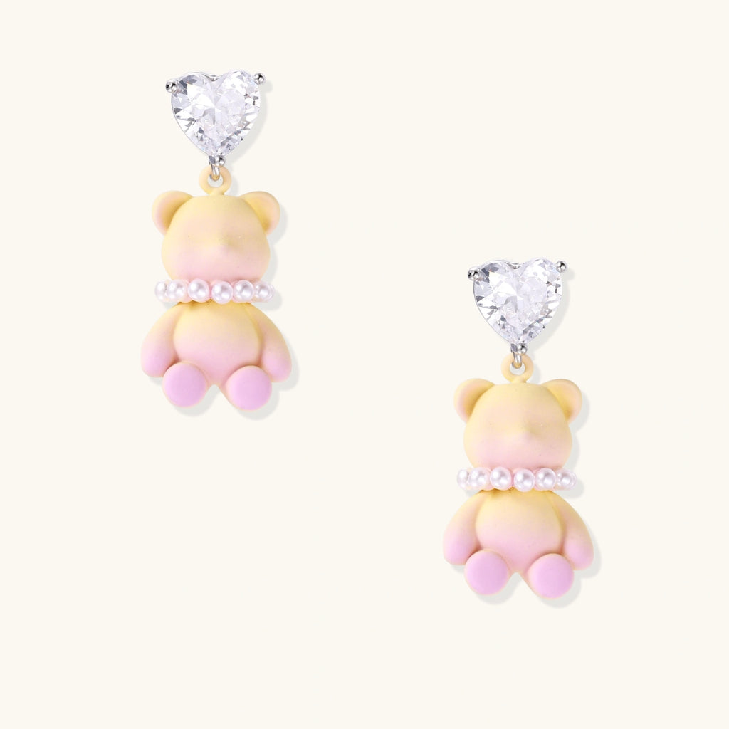 Pastel gradient teddy bear drop earrings with clear heart studs and pearl details on white background.