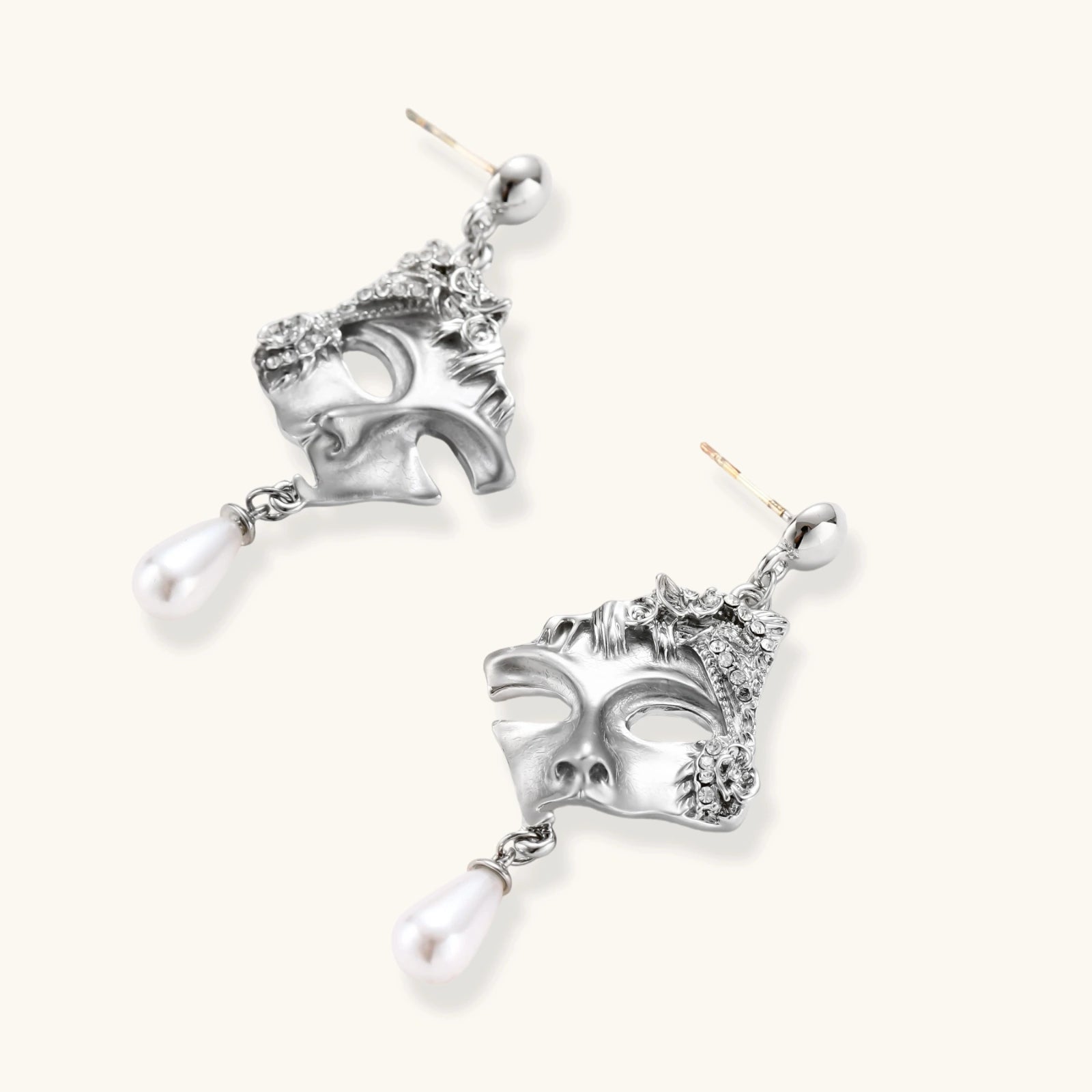 Ornate silver-toned masquerade mask jewelry set featuring rhinestone details and pearl drop earrings on white background.