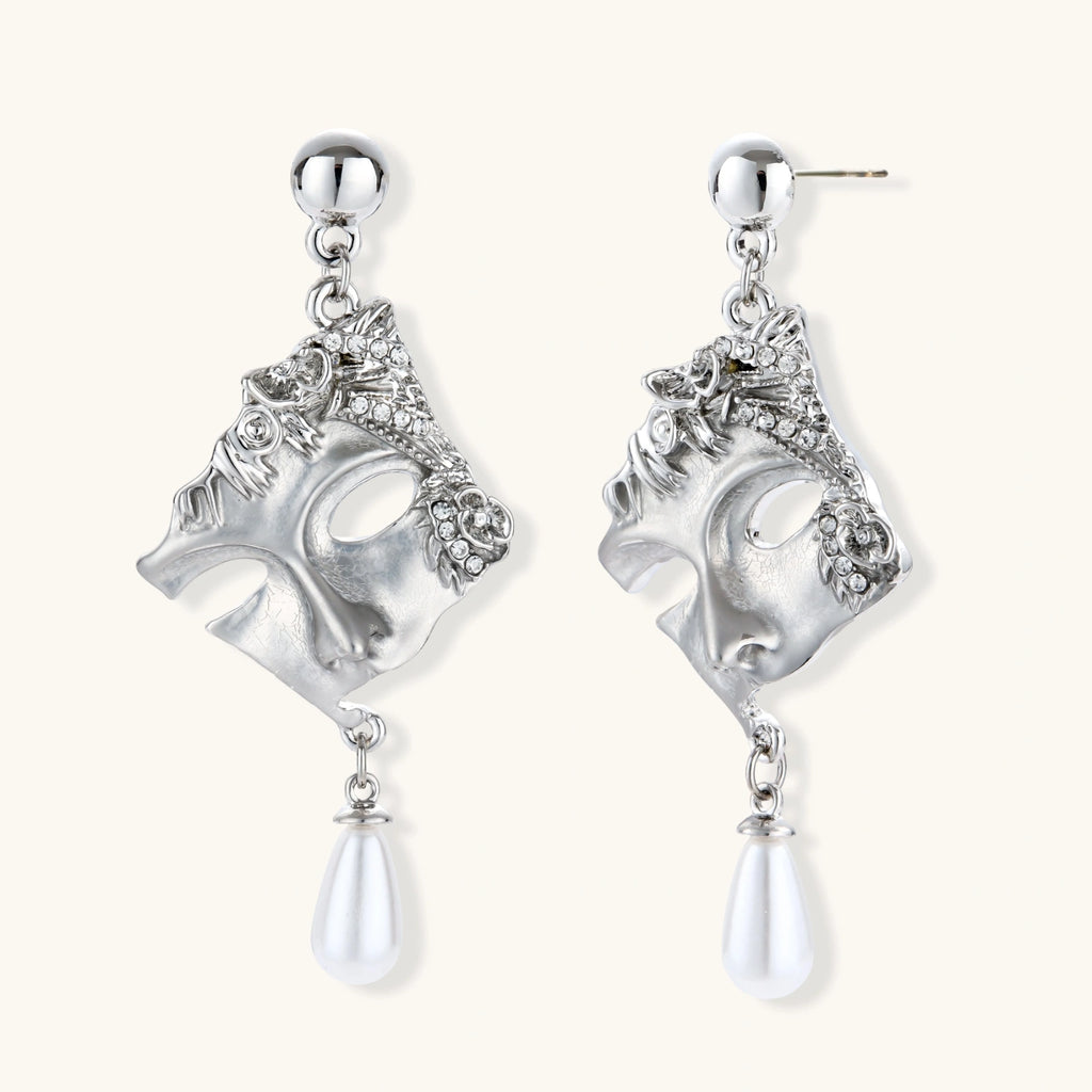 Ornate silver-toned masquerade mask jewelry set featuring rhinestone details and pearl drop earrings on white background.