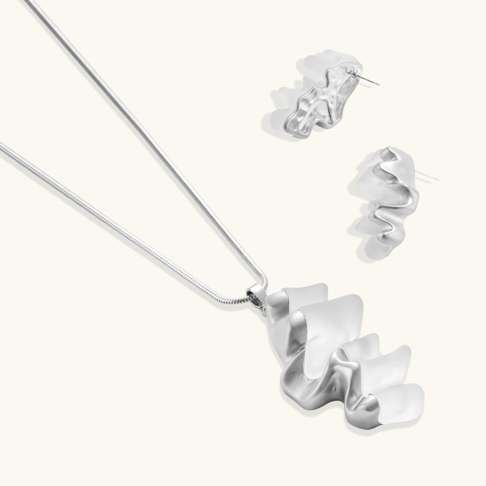 Modern sculptural jewelry set with flowing ribbon-like earrings and matching pendant in eco-zinc alloy finish