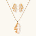 Sculptural gold-toned jewelry set featuring wavy organic earrings and matching necklace pendant with translucent resin accents.