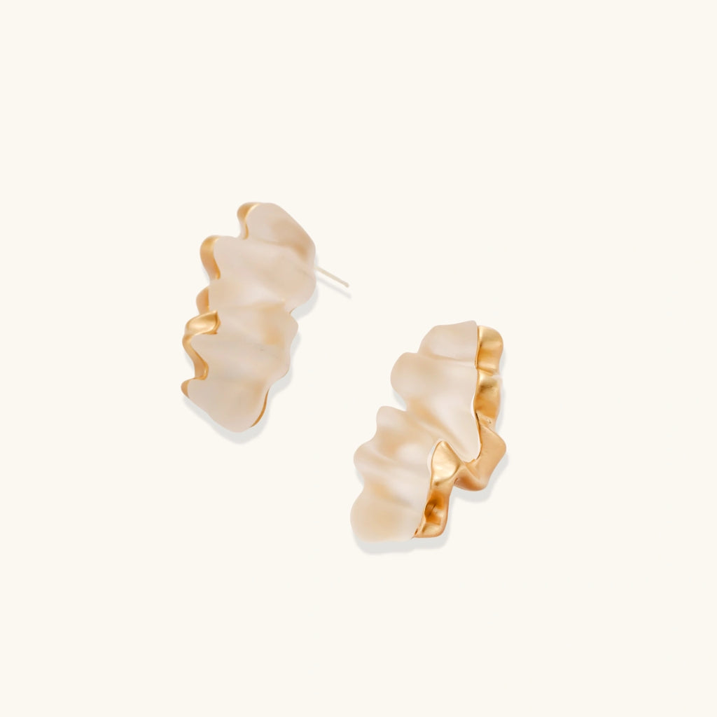Sculptural gold-toned jewelry set featuring wavy organic earrings and matching necklace pendant with translucent resin accents.