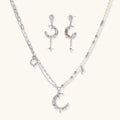 Mixed-metal jewelry set featuring layered necklaces with crescent moon pendant and pearl beads, plus matching star-drop earrings.