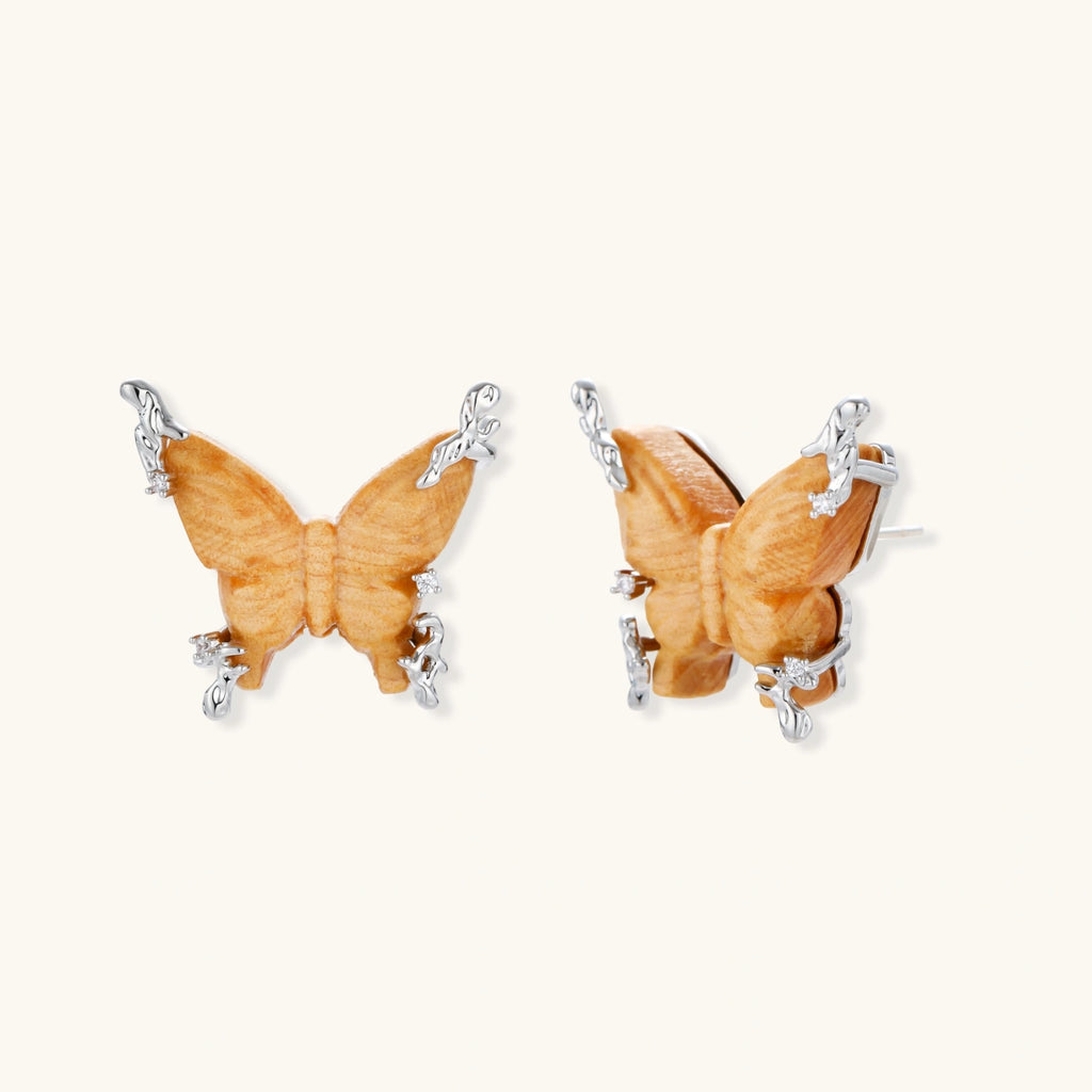 Amber wood butterfly pendant necklace with dangling chains and matching carved wood butterfly earrings on white background.