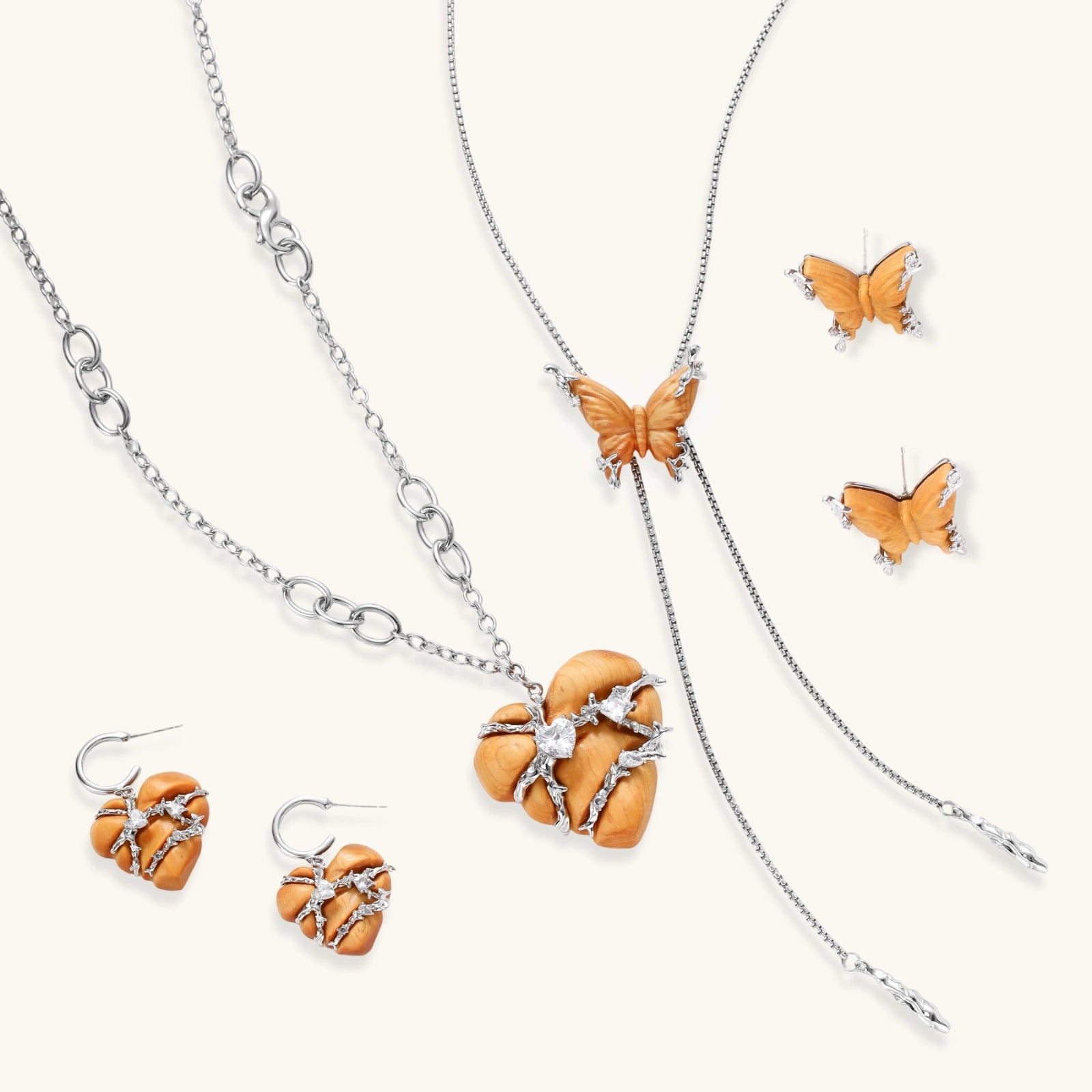 Amber wood butterfly pendant necklace with dangling chains and matching carved wood butterfly earrings on white background.