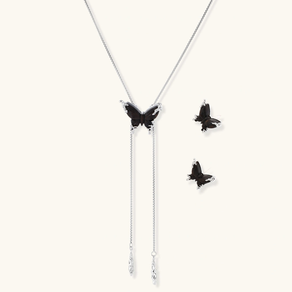 Dark wood butterfly earrings and necklace with silver chain accents on white background, showing natural grain texture.