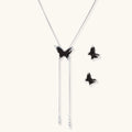 Dark wood butterfly earrings and necklace with silver chain accents on white background, showing natural grain texture.