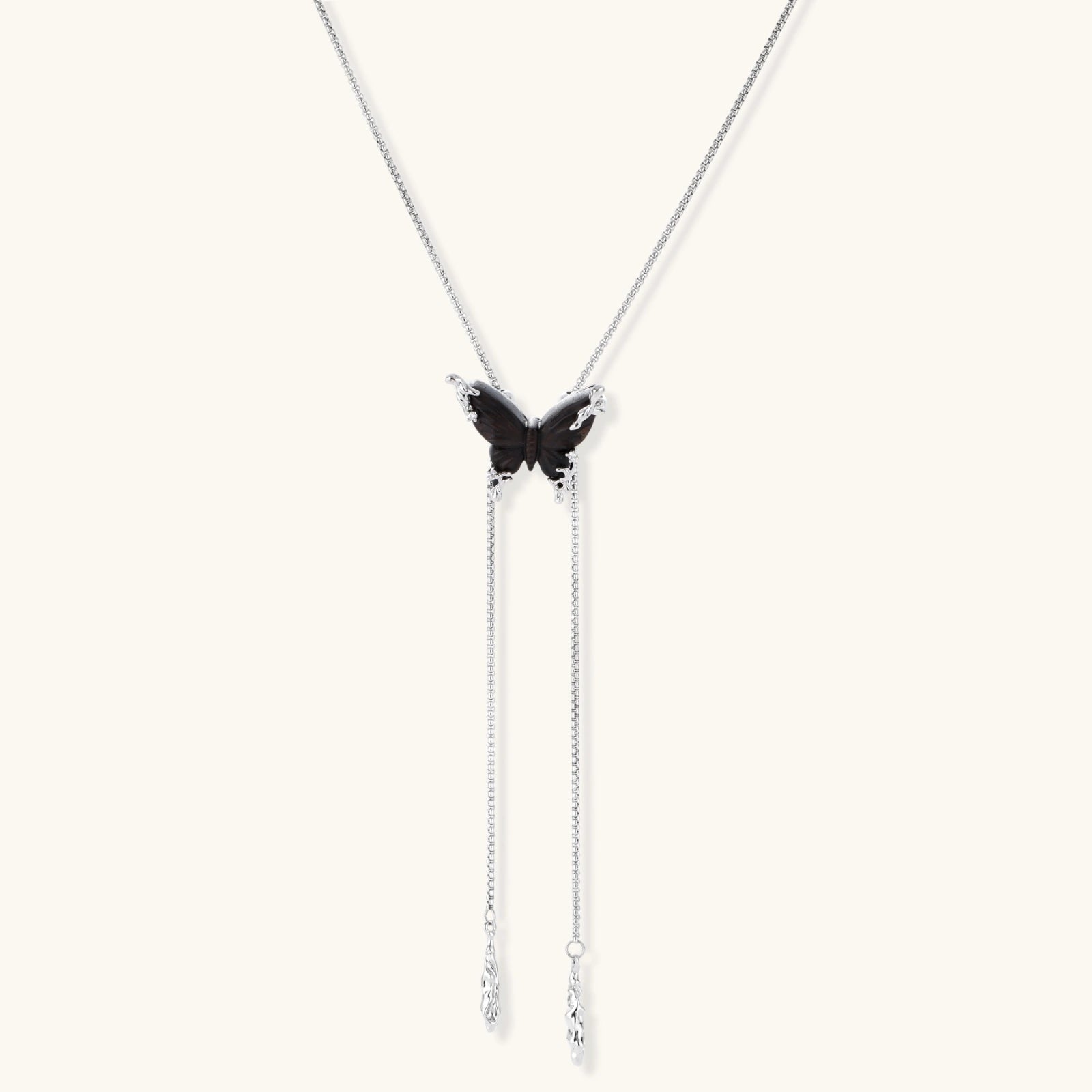 Dark wood butterfly earrings and necklace with silver chain accents on white background, showing natural grain texture.