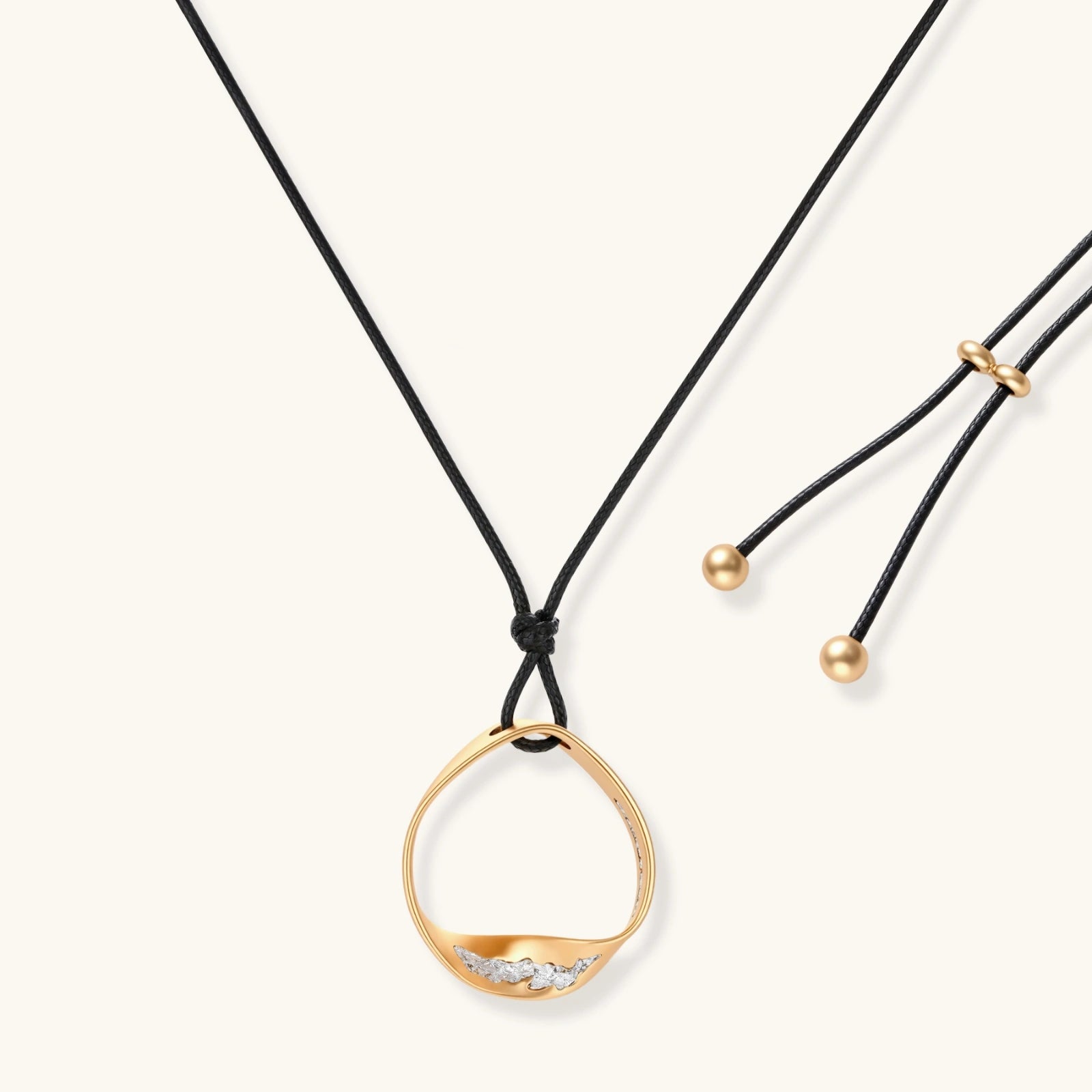 Geometric circle pendant necklace with crystal cluster on adjustable black cord, available in gold and silver finishes.