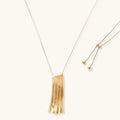 Modern adjustable necklace featuring geometric ribbed pendant with vertical lines in gold and silver finish options.