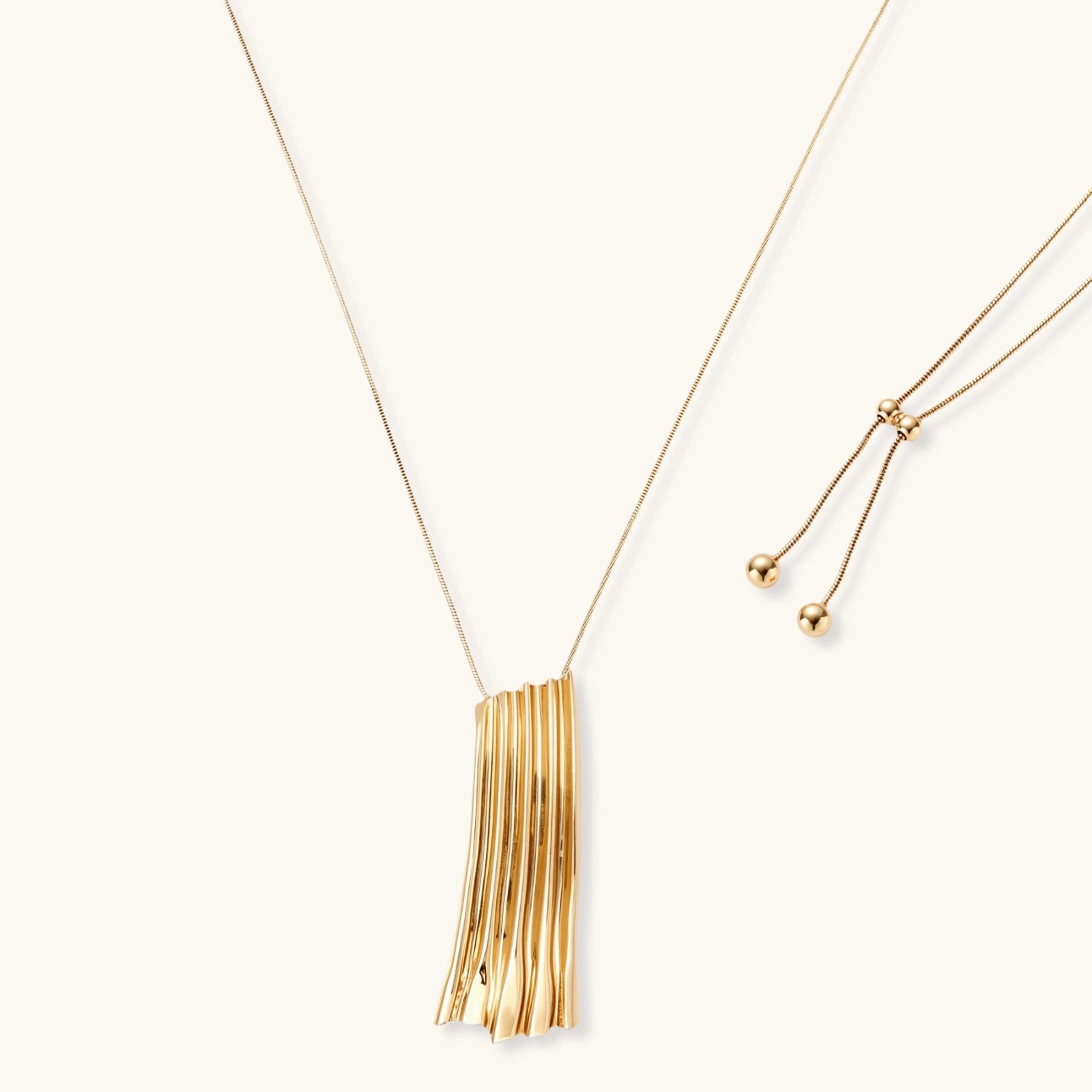 Modern adjustable necklace featuring geometric ribbed pendant with vertical lines in gold and silver finish options.