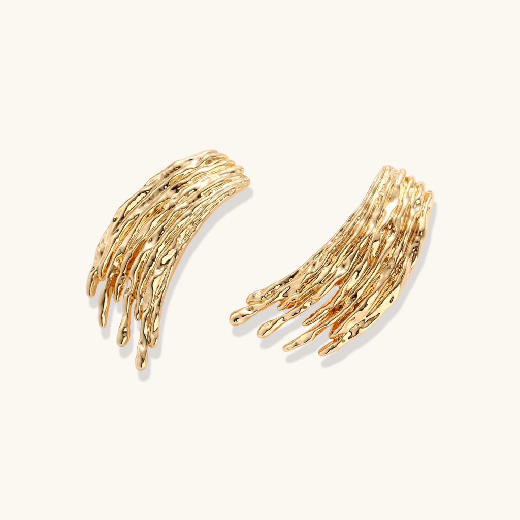 Flowing fringe earrings with cascading curved metal elements in gold tone, showing dimensional movement and sculptural design.