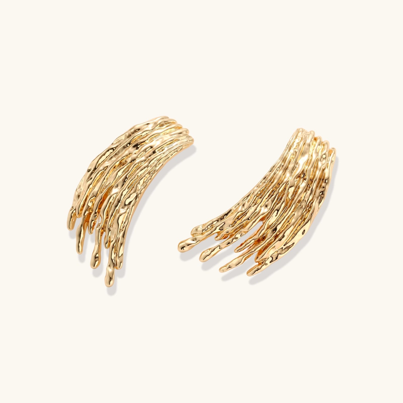Flowing fringe earrings with cascading curved metal elements in gold tone, showing dimensional movement and sculptural design.