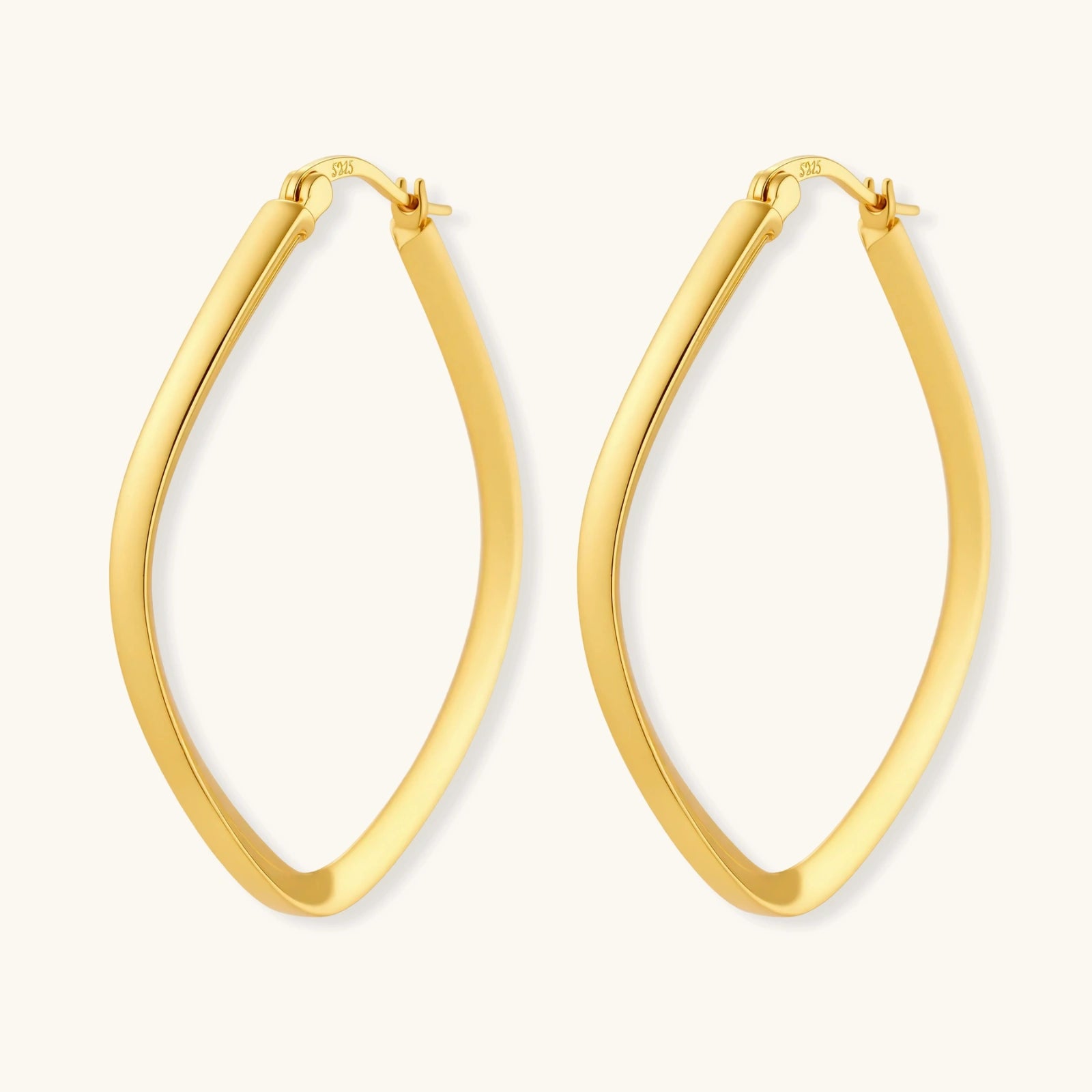 Set of geometric gold-plated sterling silver hoop earrings in oval and cushion shapes on cream background