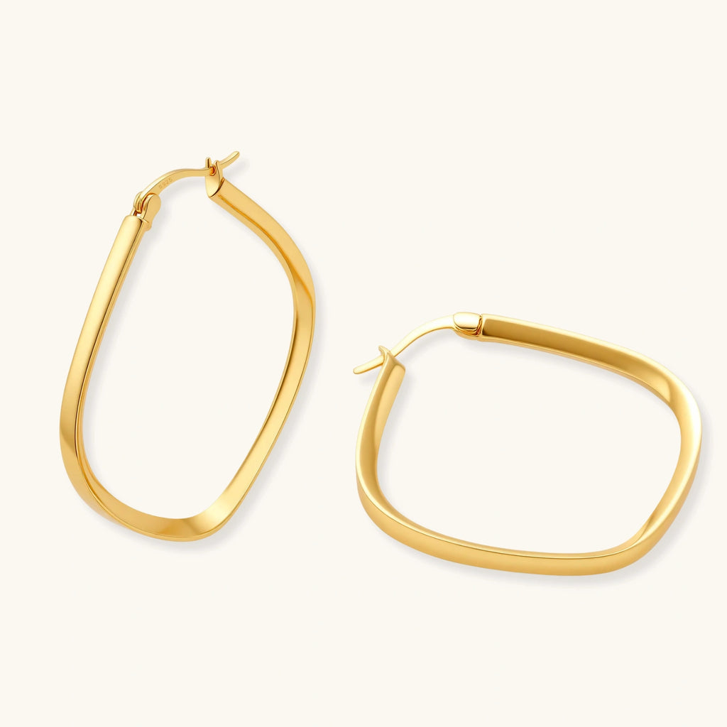 Set of geometric gold-plated sterling silver hoop earrings in oval and cushion shapes on cream background