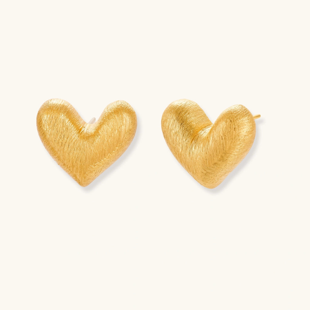 Pair of small heart-shaped stud earrings with brushed metallic finish, showing both silver and gold variants on neutral background.
