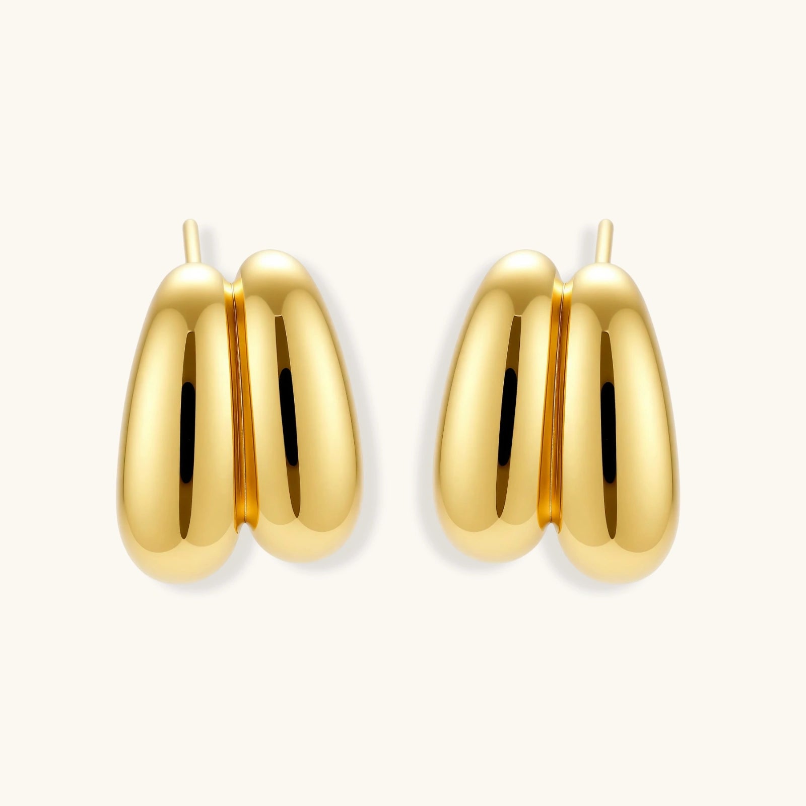 Chunky 18K gold-plated sterling silver hoop earrings with flowing sculptural curves on white background.