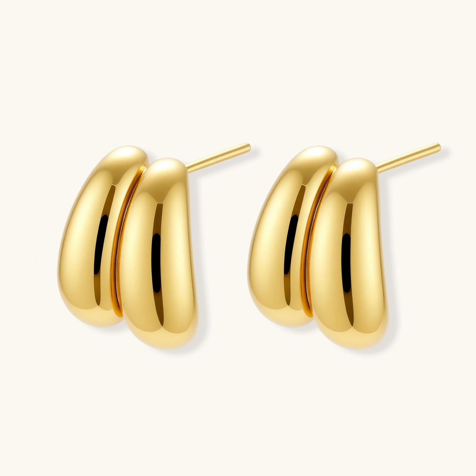 Chunky 18K gold-plated sterling silver hoop earrings with flowing sculptural curves on white background.
