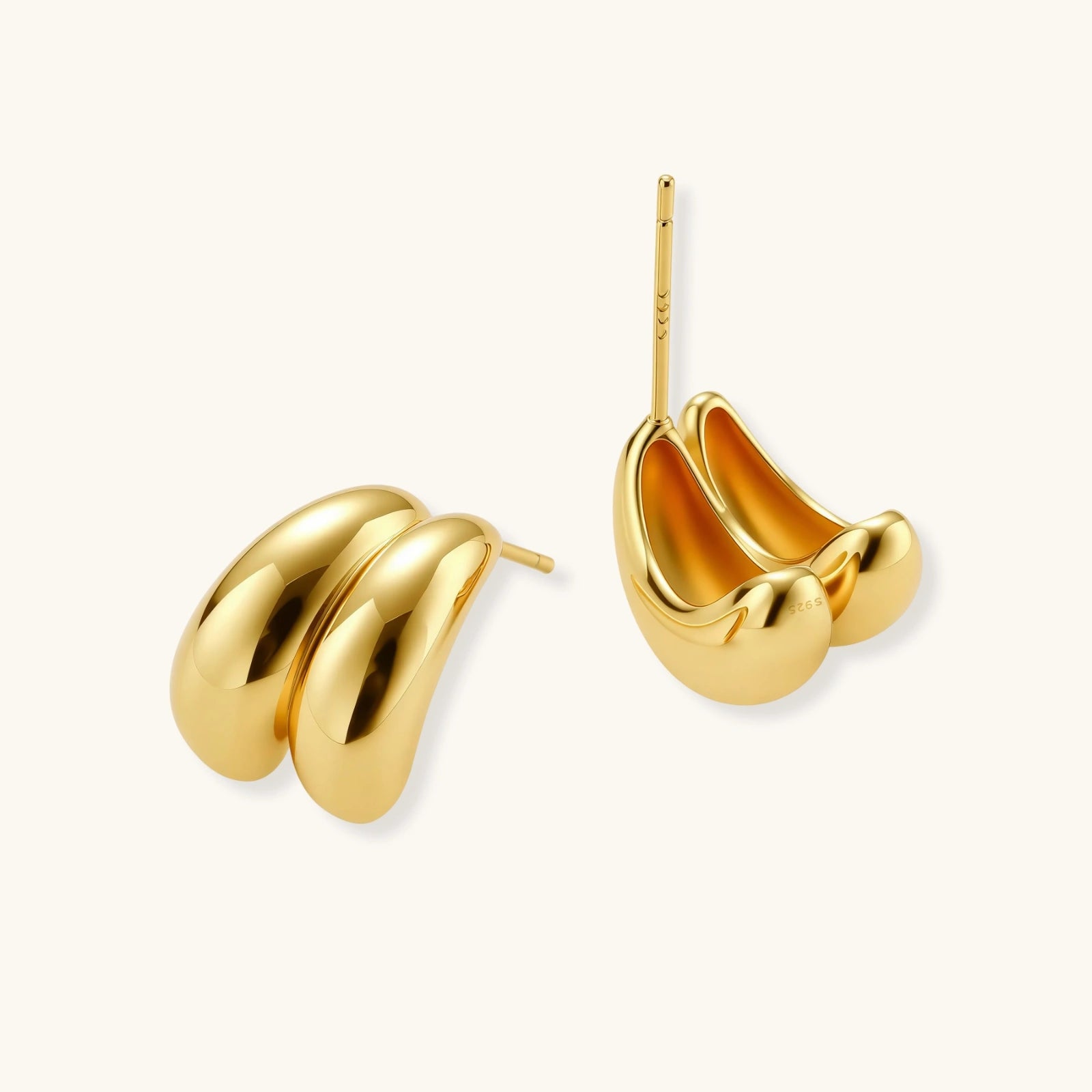 Chunky 18K gold-plated sterling silver hoop earrings with flowing sculptural curves on white background.