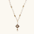Y-shaped necklace with freshwater pearls, gold filigree stations, and ornate diamond-shaped centerpiece with pearl drop