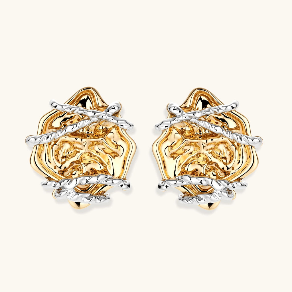 Sculptural rose-shaped stud earrings in gold with silver wire details and S925 posts on cream background.