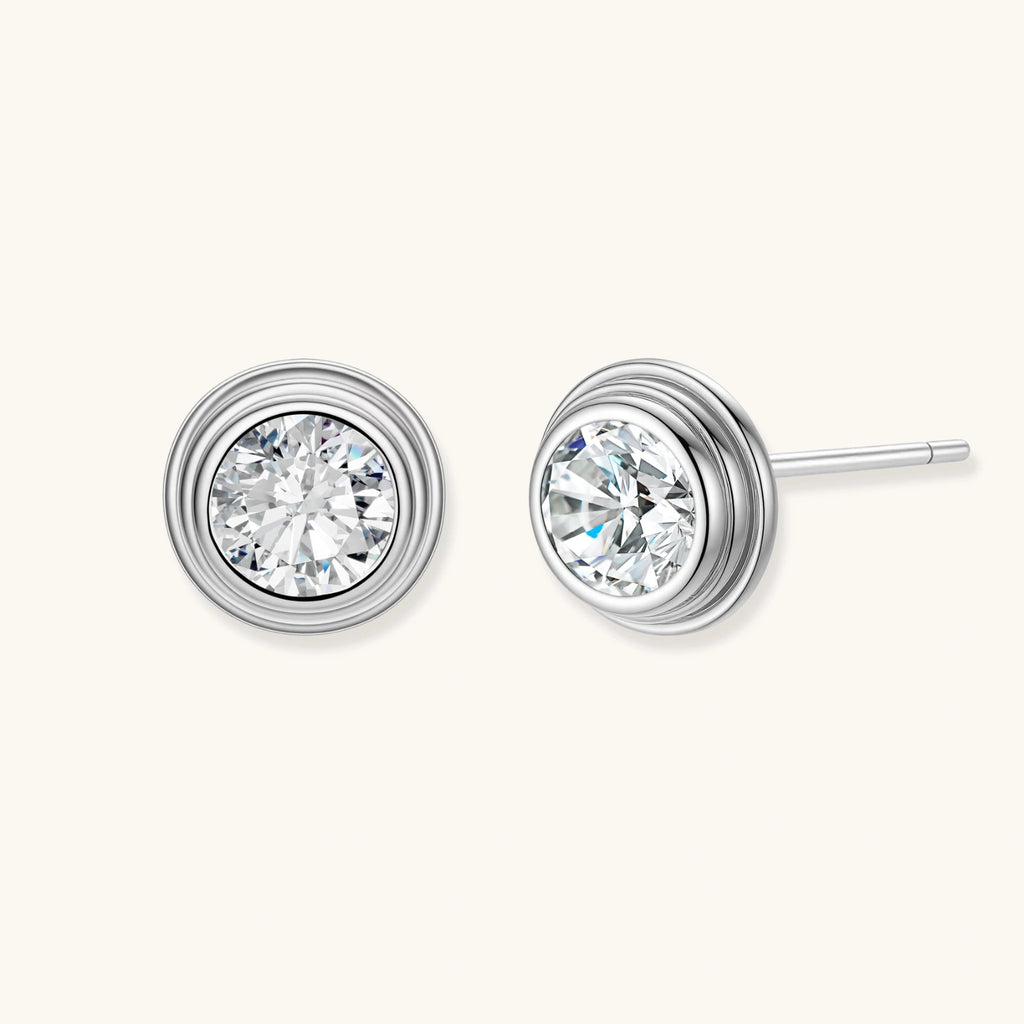 Close-up of sterling silver stud earrings featuring concentric circular frames with brilliant moissanite centers