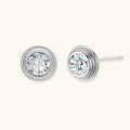 Close-up of sterling silver stud earrings featuring concentric circular frames with brilliant moissanite centers