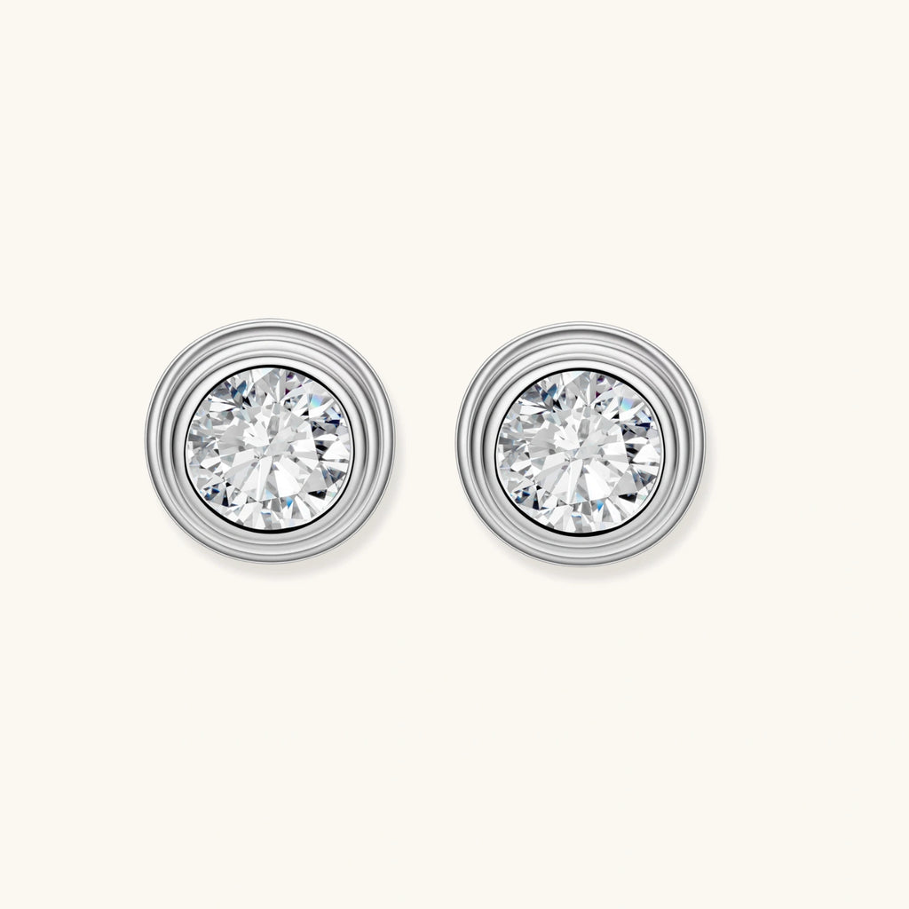 Close-up of sterling silver stud earrings featuring concentric circular frames with brilliant moissanite centers
