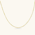 Delicate gold-plated sterling silver chain necklace with geometric segments displayed against cream background
