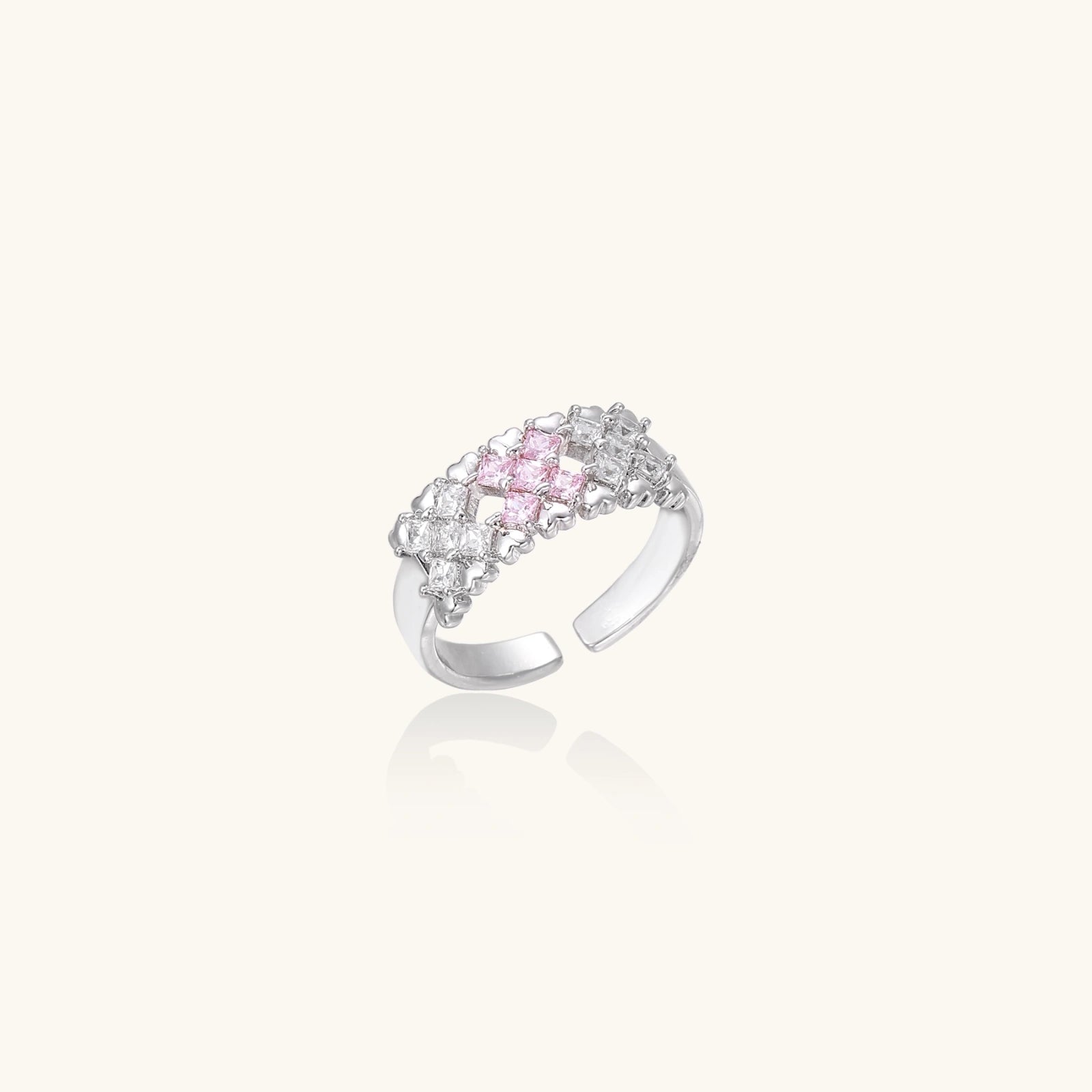 Close-up of an adjustable white gold plated ring featuring a cluster of square-cut clear and pink zirconia stones in geometric arrangement.
