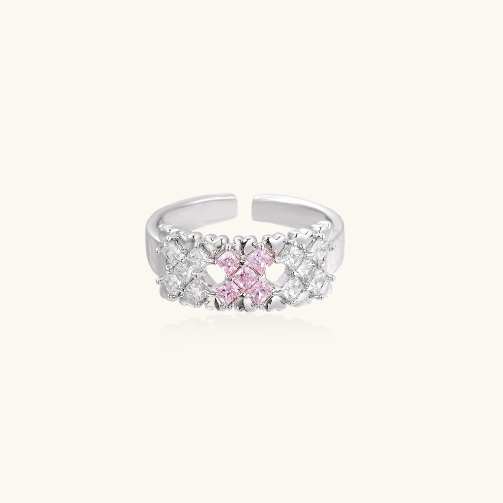 Close-up of an adjustable white gold plated ring featuring a cluster of square-cut clear and pink zirconia stones in geometric arrangement.