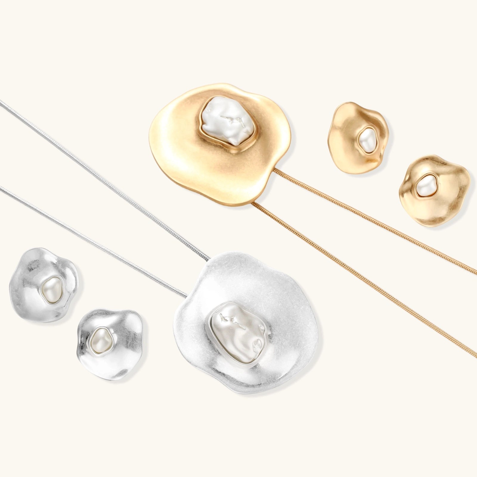 Sculptural silver necklace with flowing organic pendant featuring centered baroque pearl on white background.