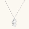 Modern sculptural pendant necklace with twisted metallic design on delicate silver chain against neutral background.