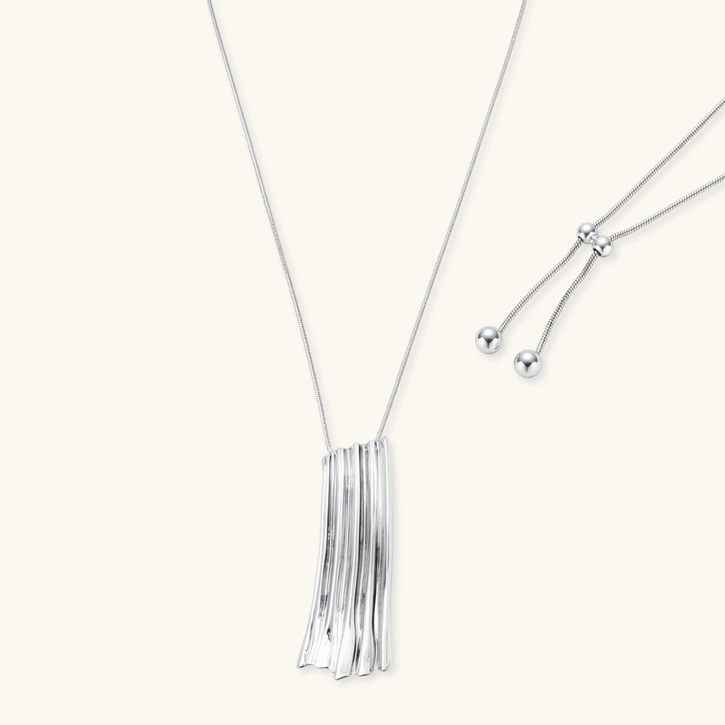 Modern silver necklace with vertical ridged pendant and adjustable chain on white background, eco-friendly zinc alloy construction.