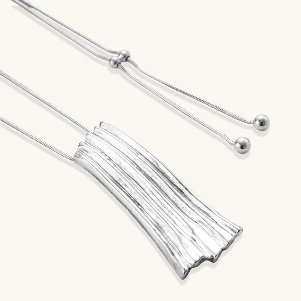Modern silver necklace with vertical ridged pendant and adjustable chain on white background, eco-friendly zinc alloy construction.