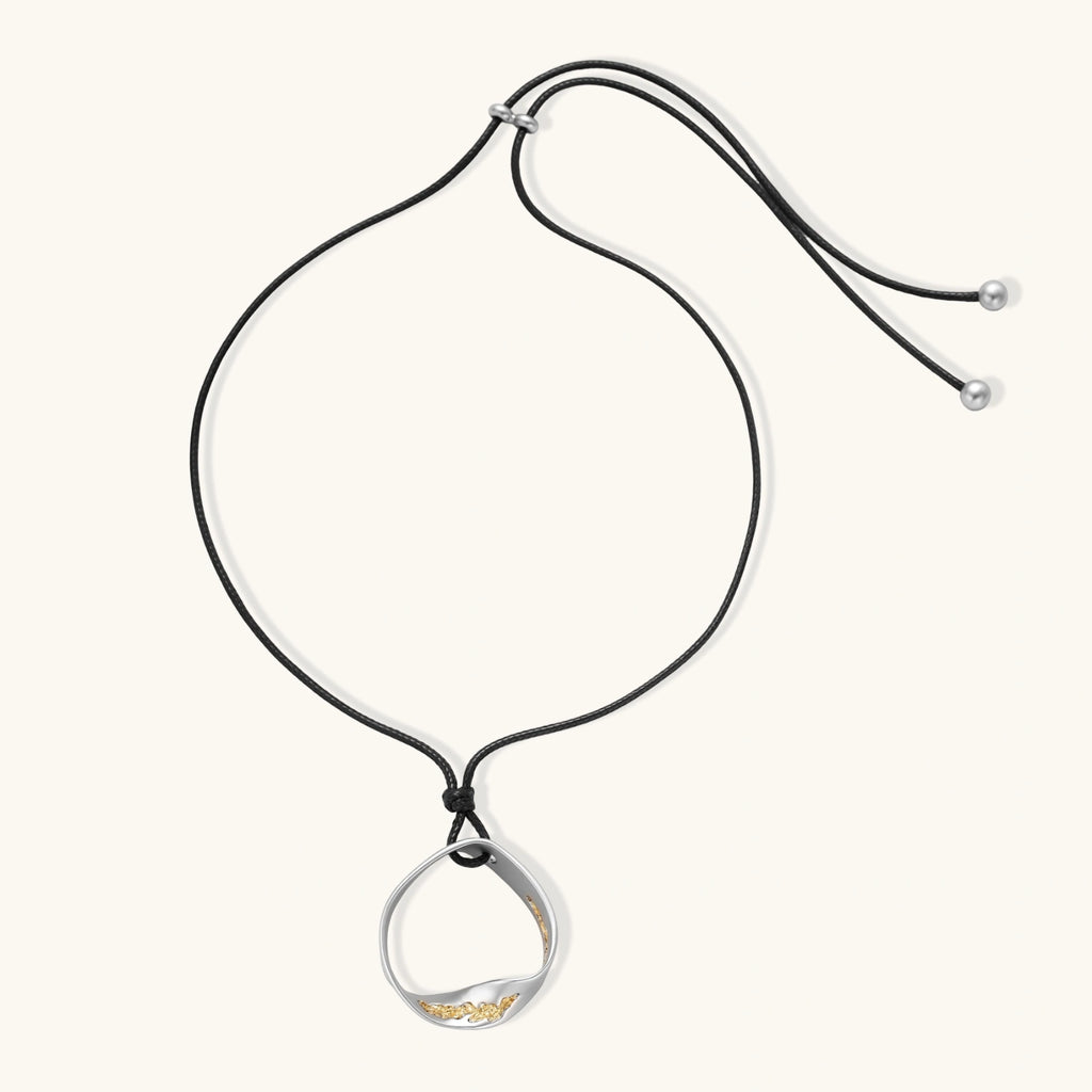 Minimalist silver and gold circle pendant on black adjustable cord, featuring eco-friendly zinc alloy construction
