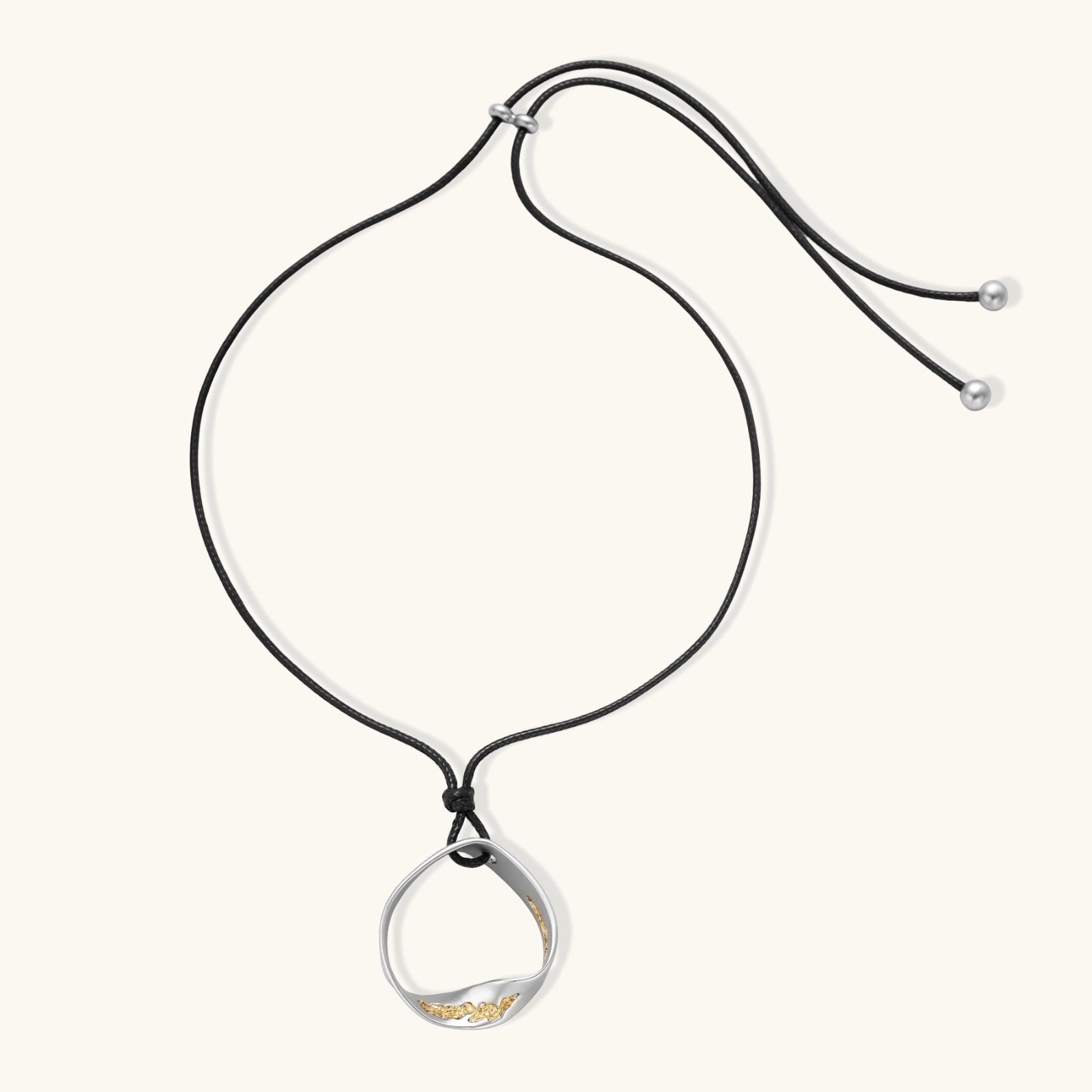 Minimalist silver and gold circle pendant on black adjustable cord, featuring eco-friendly zinc alloy construction