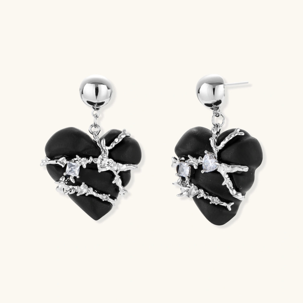 Black heart-shaped wood earrings with decorative silver chains and crystal accents hanging from silver ball studs