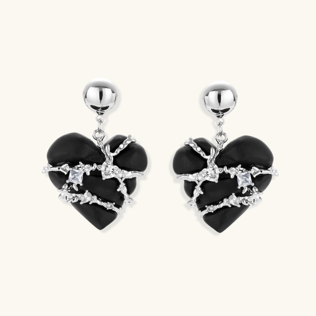 Black heart-shaped wood earrings with decorative silver chains and crystal accents hanging from silver ball studs