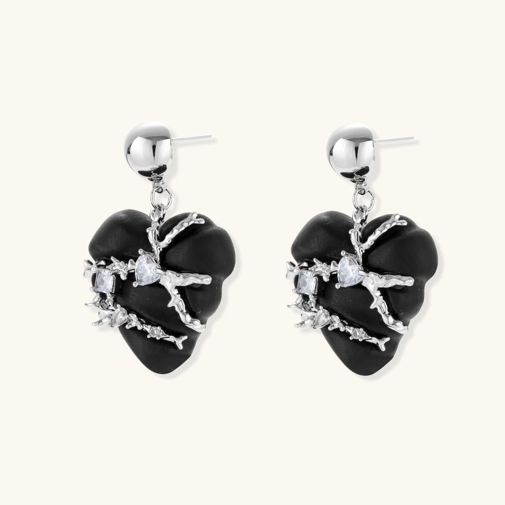 Black heart-shaped wood earrings with decorative silver chains and crystal accents hanging from silver ball studs