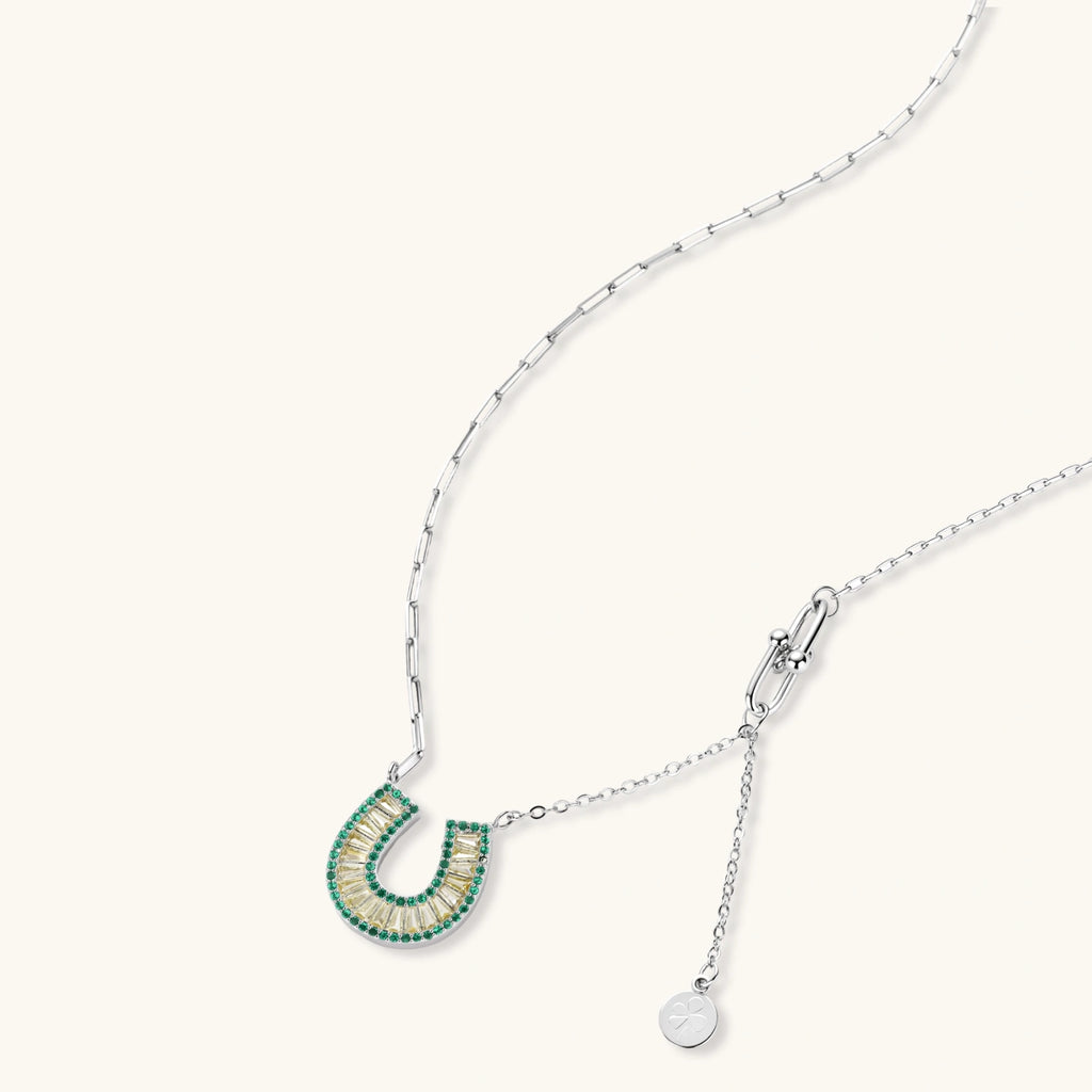 Geometric horseshoe-shaped jewelry set with radiating white zirconia center and jade-green border stones on white background.