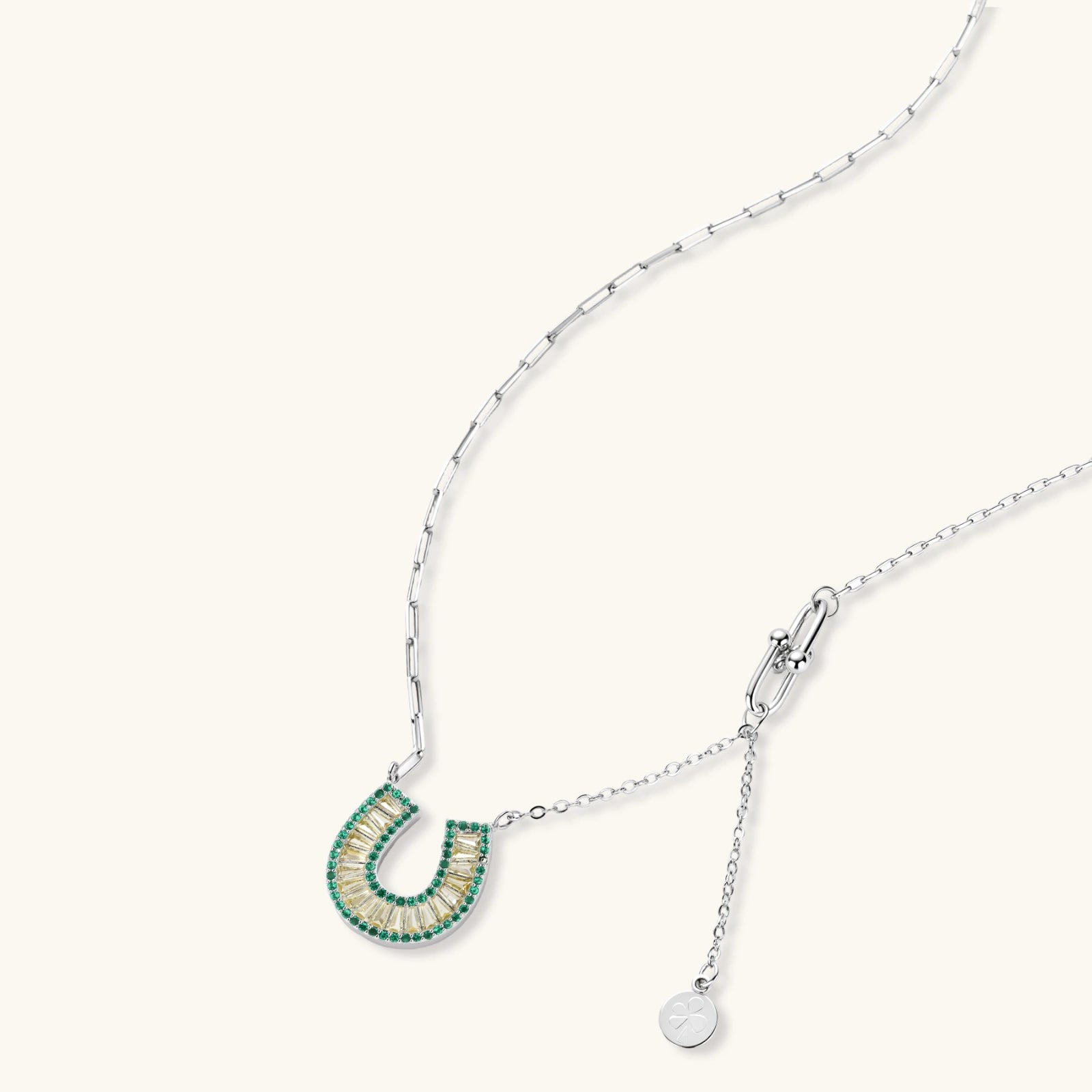 Geometric horseshoe-shaped jewelry set with radiating white zirconia center and jade-green border stones on white background.